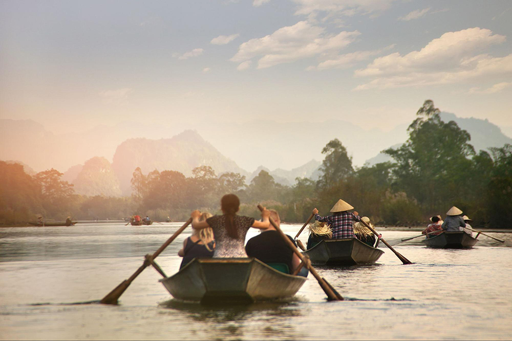Taking a boat riding along the river is an exciting experience when going to Huong Pagoda 